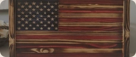 A weathered wooden American flag with distressed stars and stripes
